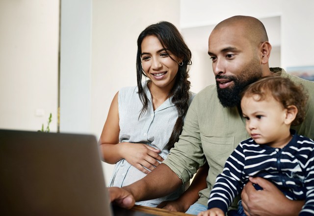 pregnant woman with husband and son looking at laptop